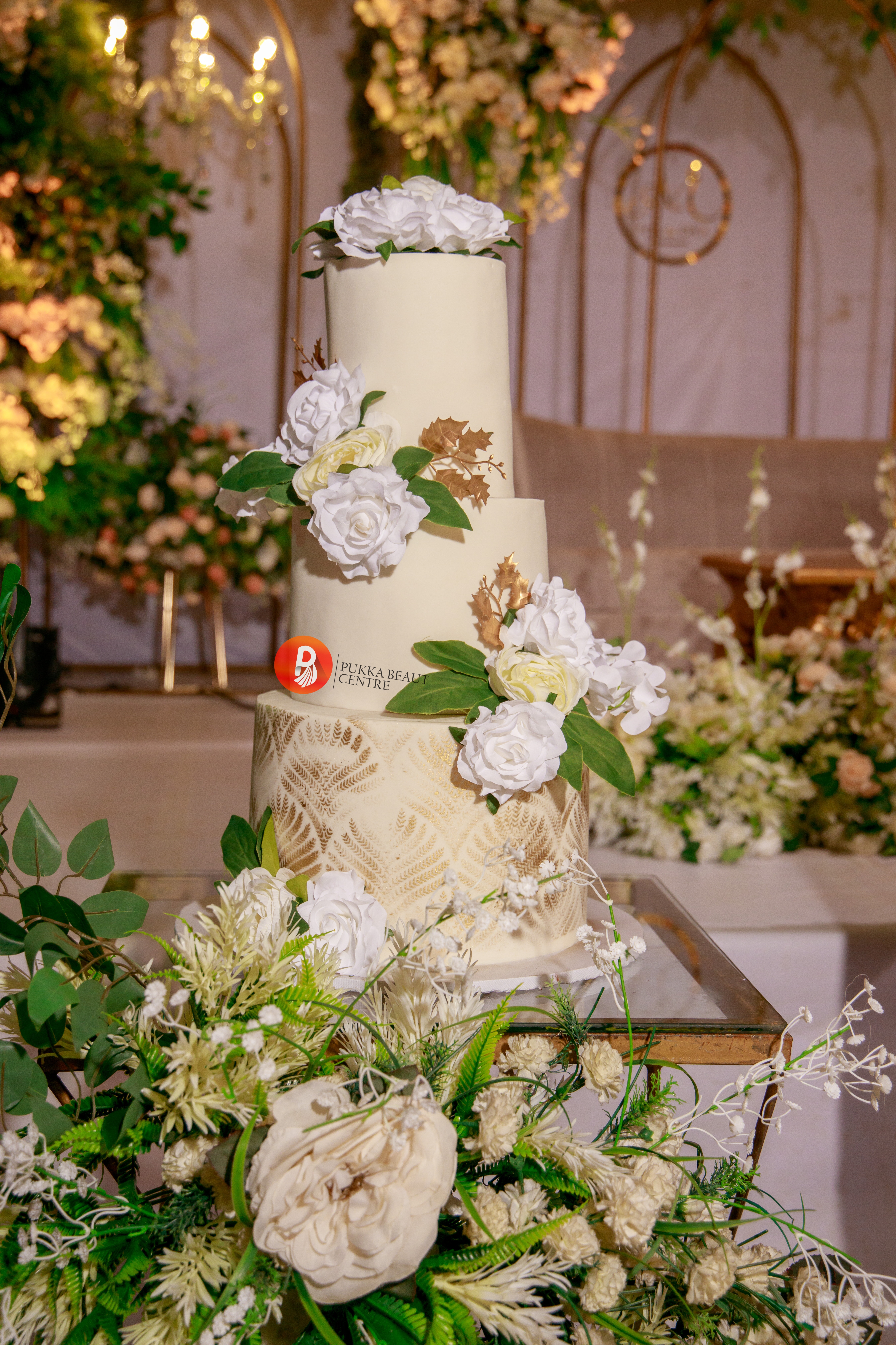 White and gold three-tier wedding cake with floral styling by Pukka Beaut